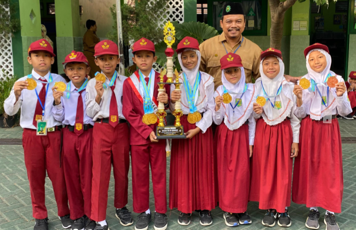 Kepala SD Muhammadiyah Bodon Bersama Siswa Berprestasi Menunjukkan Medali Emas di Halaman Sekolah